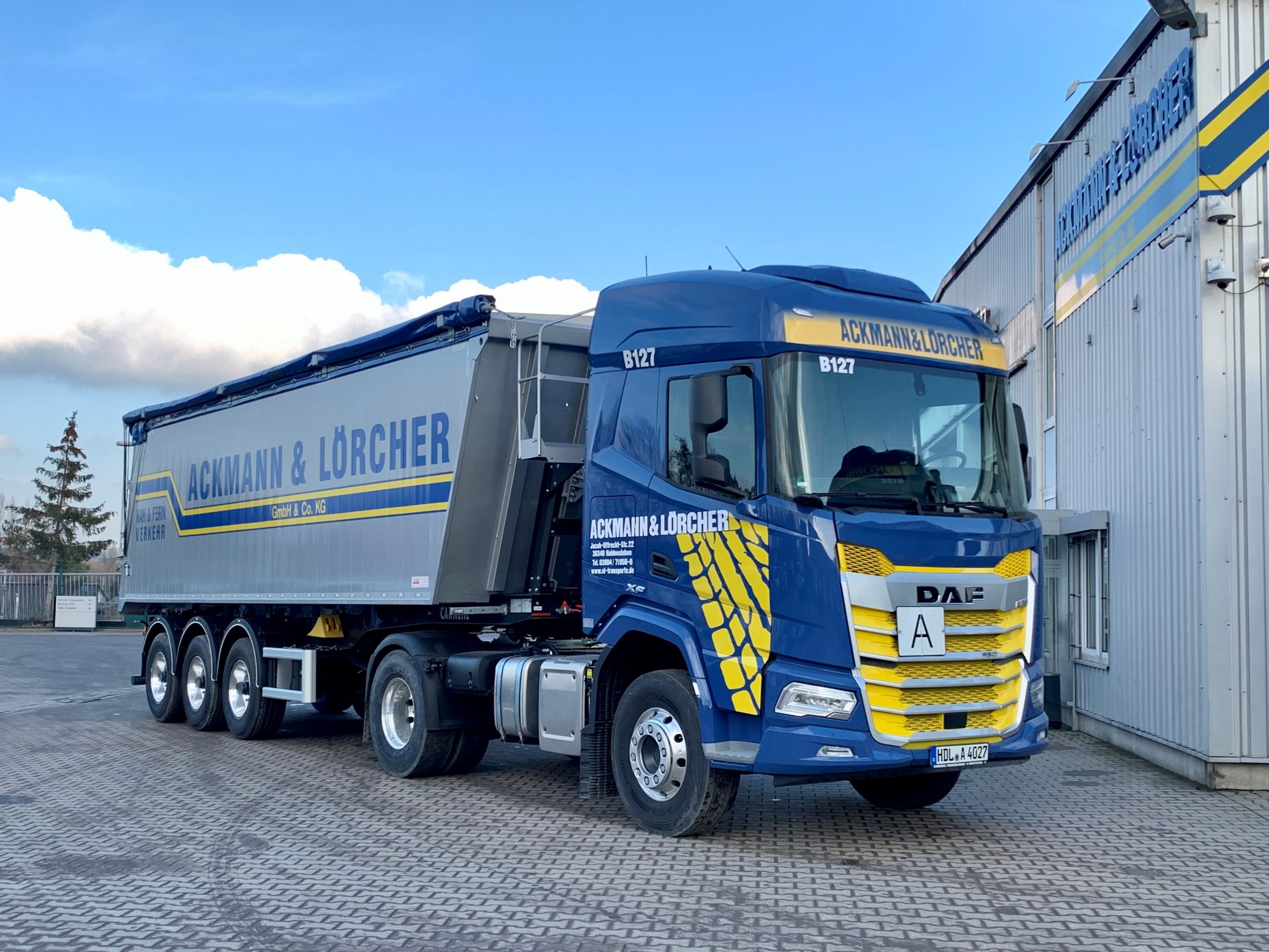 Kipper-LKW von Ackmann & Lörcher vor Firmengebäude
