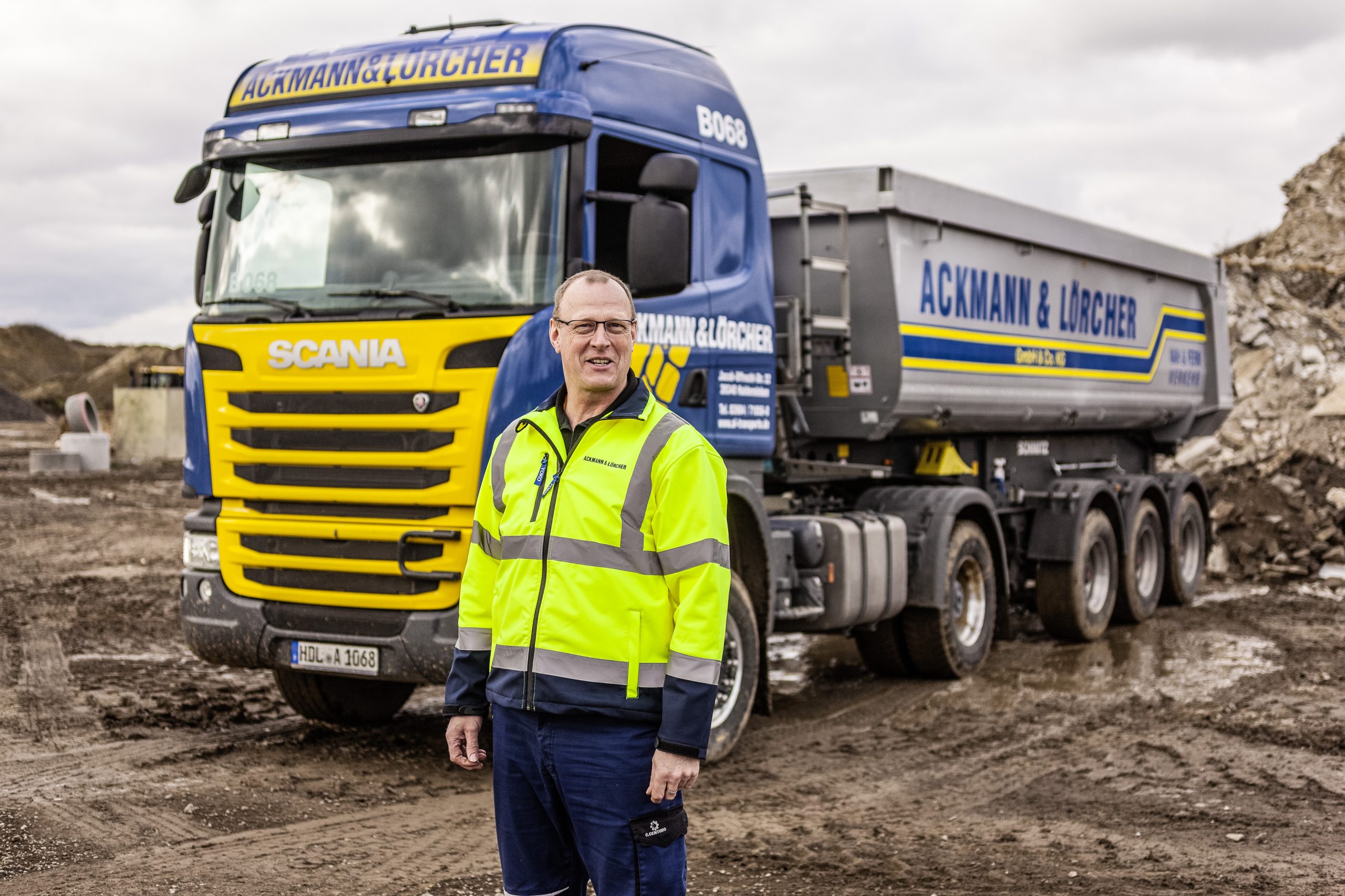 Mitarbeiter von Ackmann & Lörcher vor LKW auf Baustelle