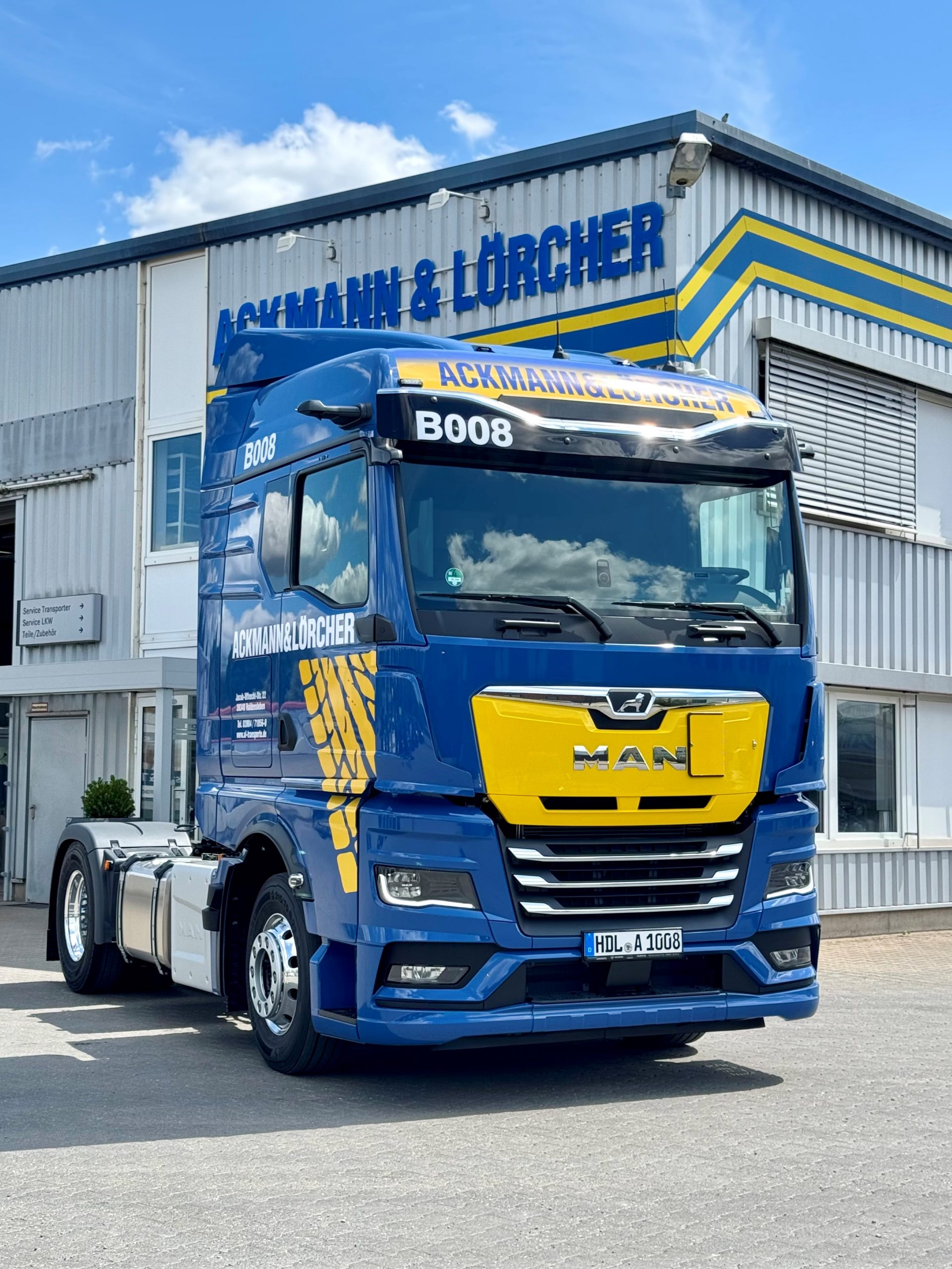MAN Schubboden-LKW von Ackmann & Lörcher vor Firmengebäude